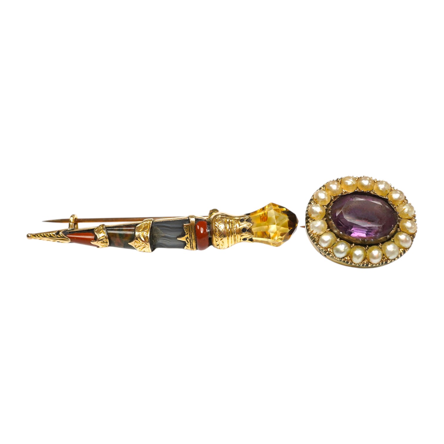 An early 20th century yellow metal, gem and Scottish hardstone set dirk brooch, 55mm, together with a George IV yellow metal, amethyst and split pearl set oval mourning brooch. Condition - poor to fair